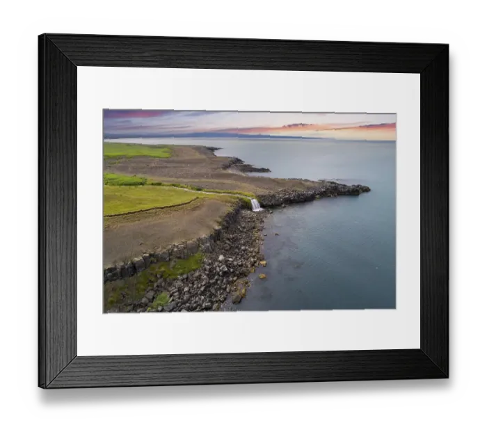 Framed Print : Aerial view in the evening light of a waterfall that flows over basalt columns into the sea Framed Print : Aerial view in the evening light of a waterfall that flows over basalt columns into the sea