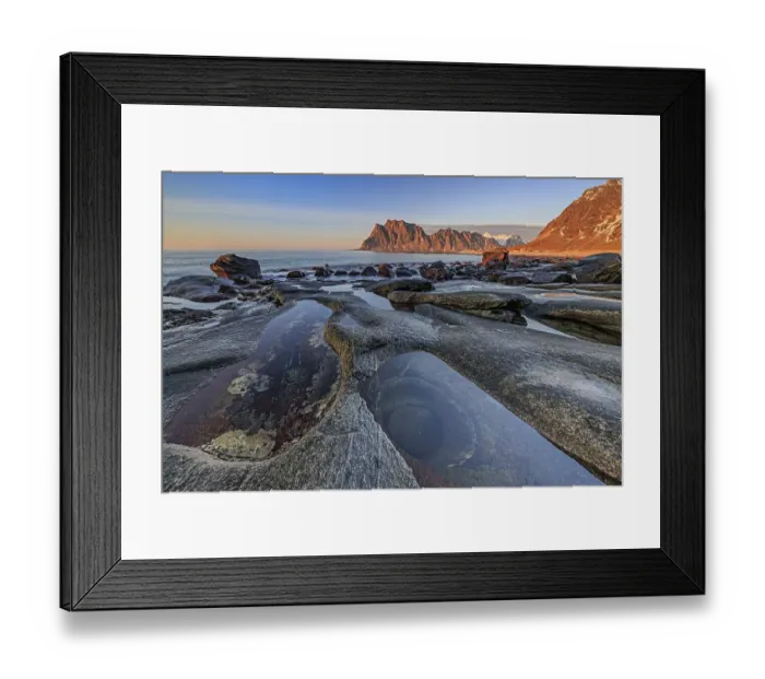Framed Print : Rocky coast in front of steep mountains in the evening light