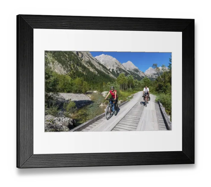 Framed Print : Cyclists, mountain bikers cycle on bridge over mountain stream Framed Print : Cyclists, mountain bikers cycle on bridge over mountain stream