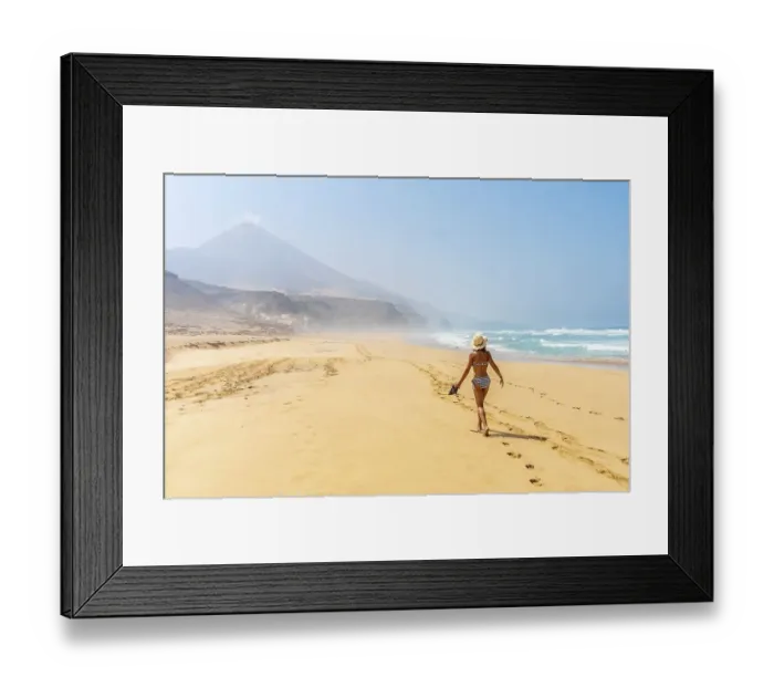 Framed Print : A young woman walking alone on the wild Cofete beach of the Jandia natural park