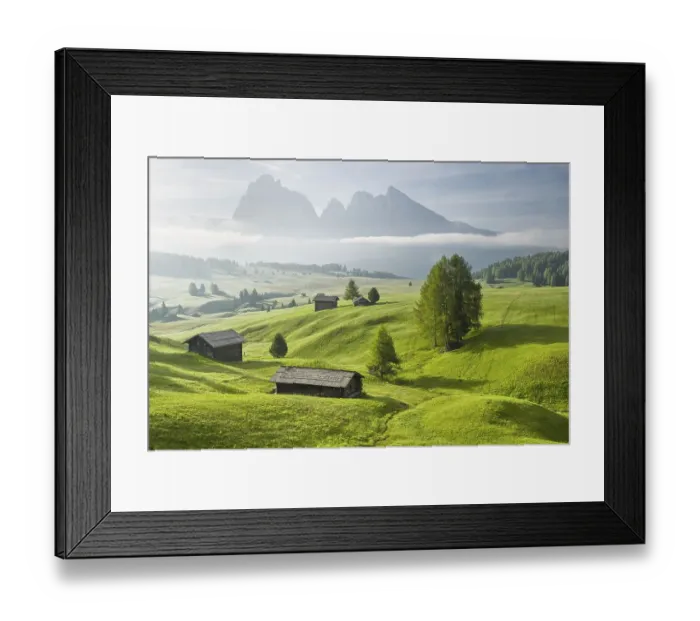Framed Print : Alpine huts on green pastures in front of mountains