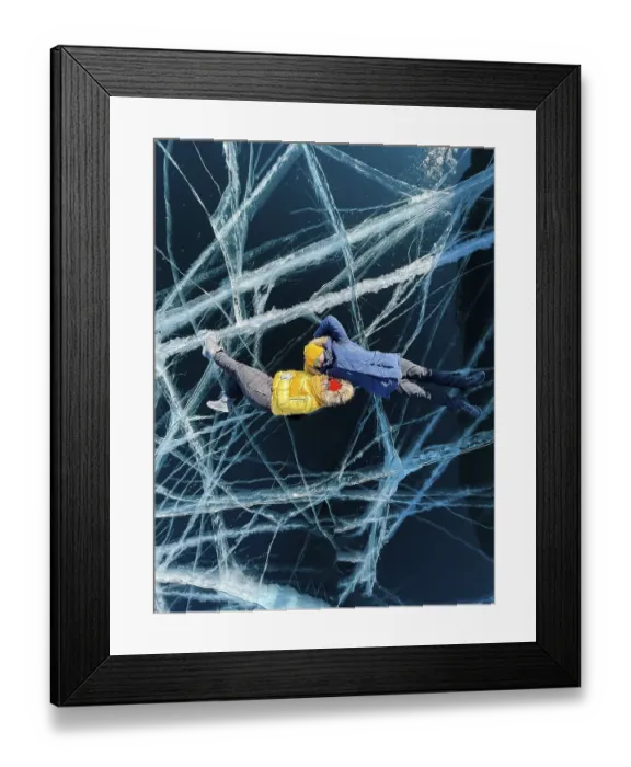 Framed Print : Happy couple lying on the frozen winter Lake Baikal wearing winter clothes Framed Print : Happy couple lying on the frozen winter Lake Baikal wearing winter clothes