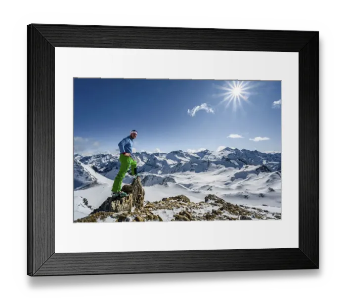 Framed Print : Man, ski tourer looks over snow-covered mountain ranges