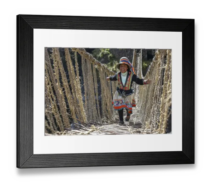 Framed Print : Laughing local girl in traditional costume walks over Inca suspension bridge Q'iswachaka