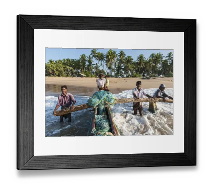 Framed Print : Fishermen at work, fishermen pushing fishing boat from sandy beach into the sea