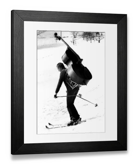 Framed Print : Man is skiing with bass ca. 1970s Framed Print : Man is skiing with bass ca. 1970s