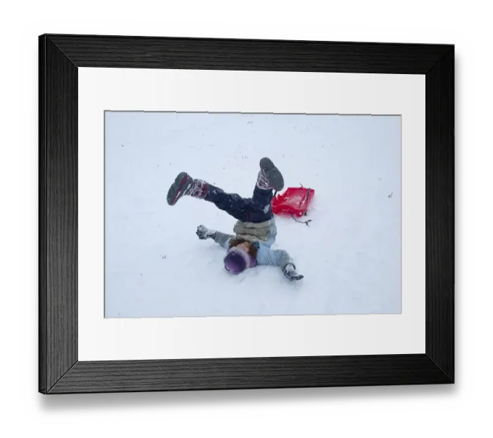 Framed Print : Girls rolling in the snow while sledding