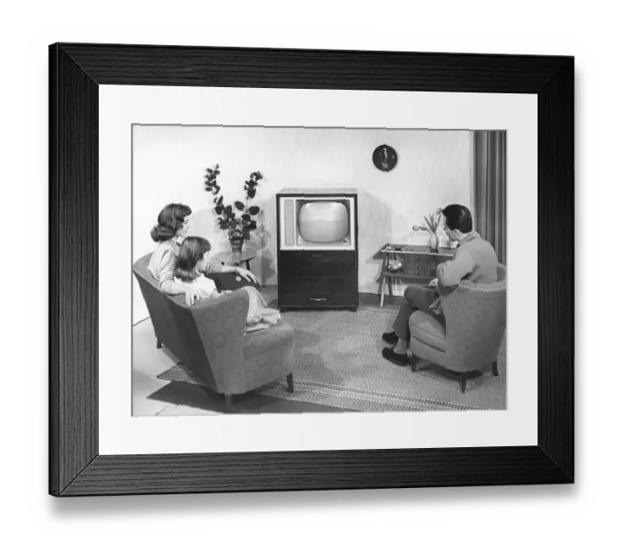 Framed Print : A model family in front of the television in a model living room