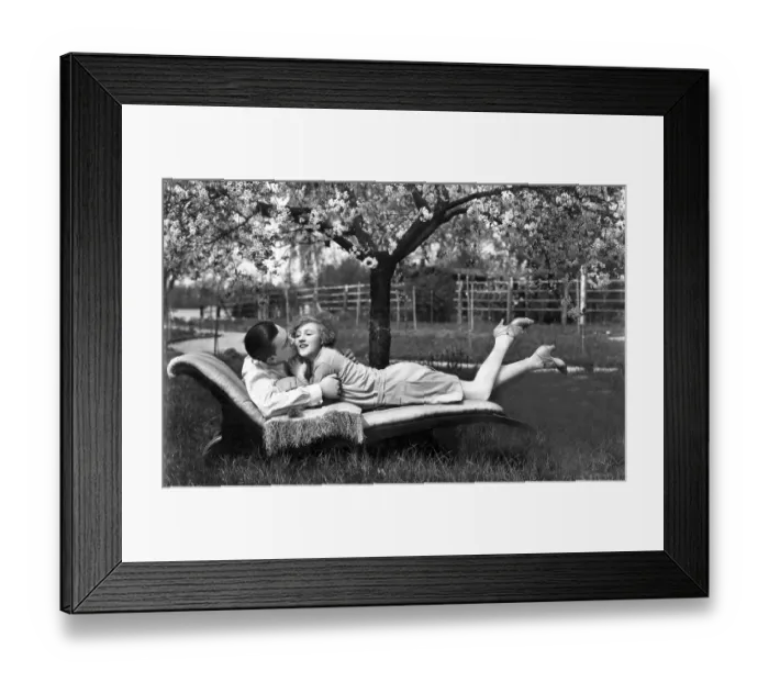 Framed Print : Man and woman lying outdoors on a sofa Framed Print : Man and woman lying outdoors on a sofa