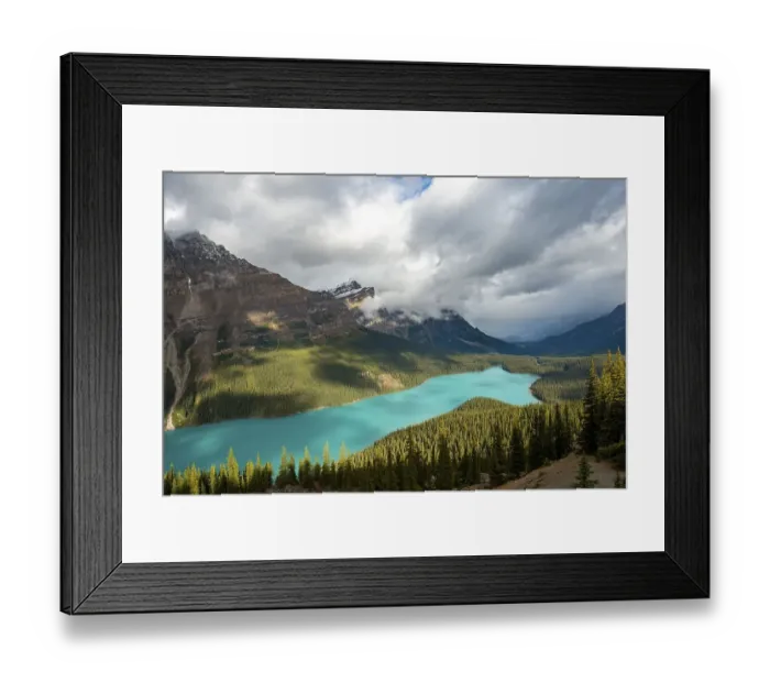 Framed Print : Cloudy mountain peaks, turquoise glacial lake surrounded by forest Framed Print : Cloudy mountain peaks, turquoise glacial lake surrounded by forest