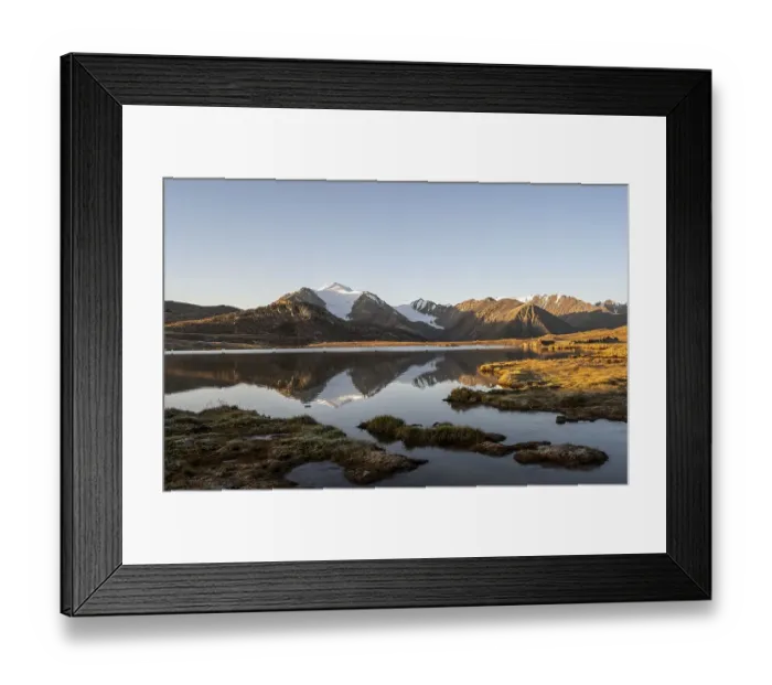 Framed Print : Glaciated mountain peaks reflected in a mountain lake at sunset