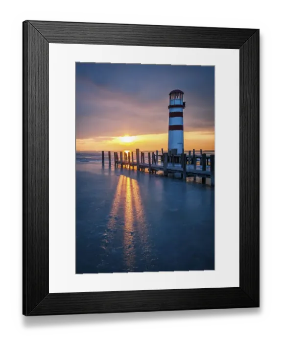 Framed Print : Winter landscape with lighthouse on a lake at sunset