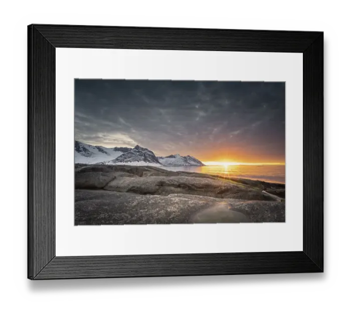 Framed Print : Rocky beach of Tungeneset, snow-covered mountain peaks in the warm sunlight above the sea Framed Print : Rocky beach of Tungeneset, snow-covered mountain peaks in the warm sunlight above the sea