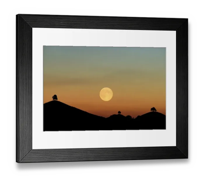Framed Print : Double exposure, full moon before sunset with trees on moraine hill