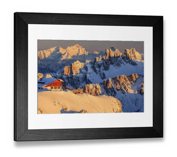 Framed Print : Mountain hut at sunset in the snow in front of rugged mountains