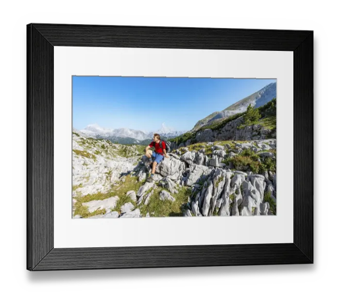 Framed Print : Hiker sitting on a stone, in the back summit of the Watzmann