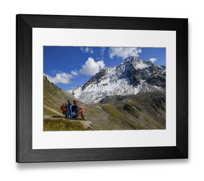 Framed Print : Mountaineer with backpack on stone and Sellrain mountains in the background