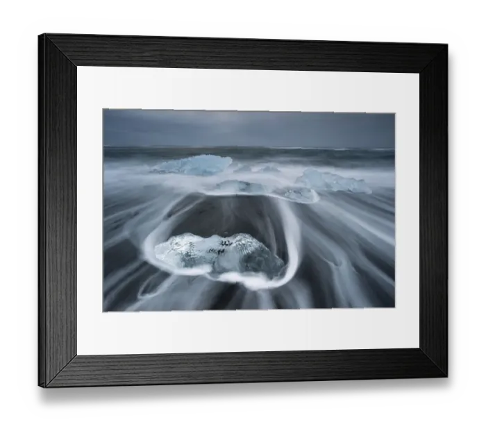 Framed Print : Melting icebergs lying in the strong surf on the black volcanic beach at Joekulsarlon