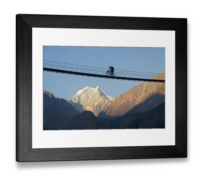 Framed Print : Cyclist crossing a suspension Bridge over Kali Ghandaki Valley Framed Print : Cyclist crossing a suspension Bridge over Kali Ghandaki Valley