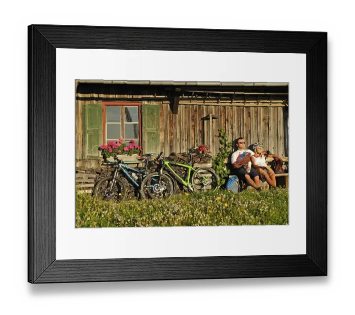 Framed Print : Mountain bikers resting in front of an old farmhouse on Kraftalm alp