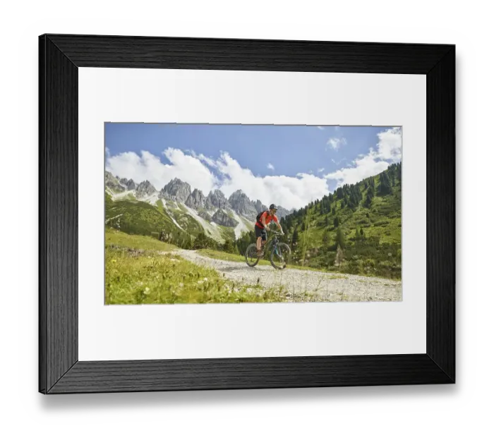 Framed Print : Mountain Biker rides a forest road