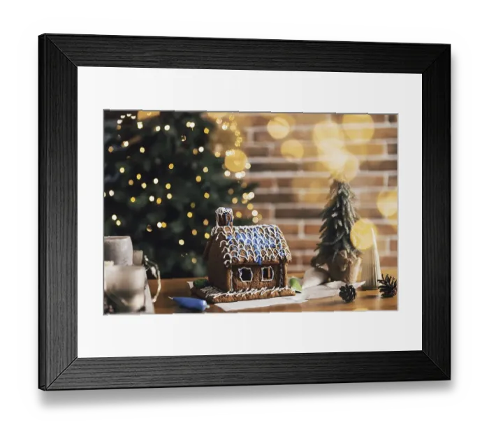 Framed Print : Little homemade gingerbread house standing on table with decorations