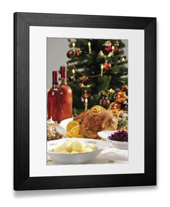 Framed Print : Roast turkey on a festive table setting served with red cabbage and dumplings in front of a decorated Christmas tree