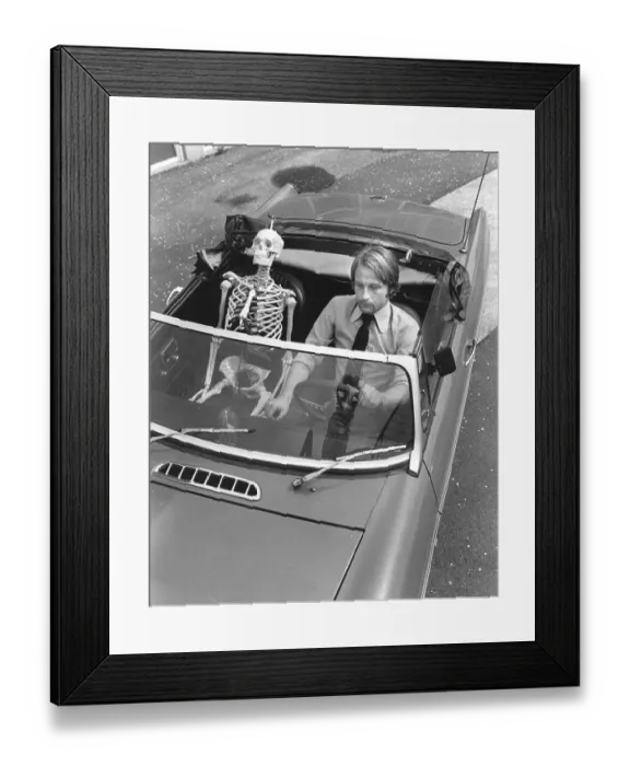 Framed Print : Skeleton and man driving car, England