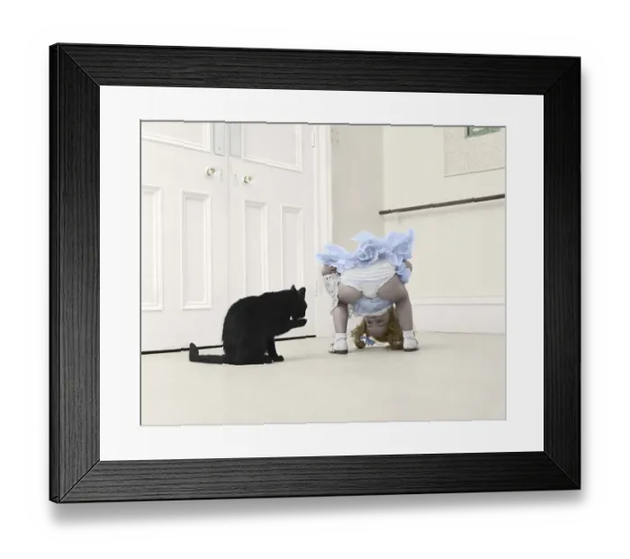 Framed Print : Little girl playing with black cat Framed Print : Little girl playing with black cat