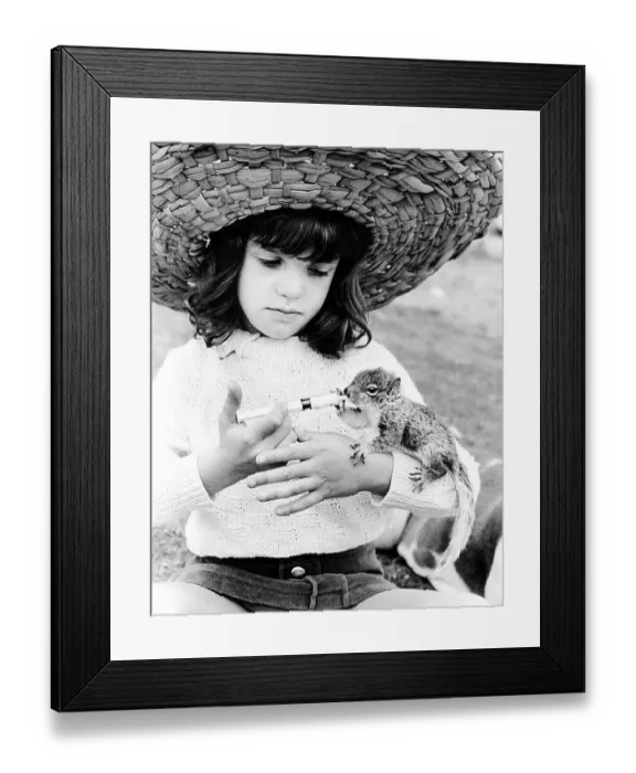 Framed Print : Girl with straw hat feeding chipmunks