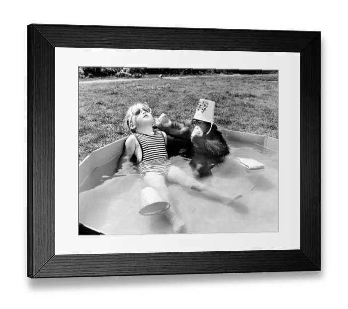 Framed Print : Girl with monkey sitting relaxed in the swimming pool and bathing in the sun