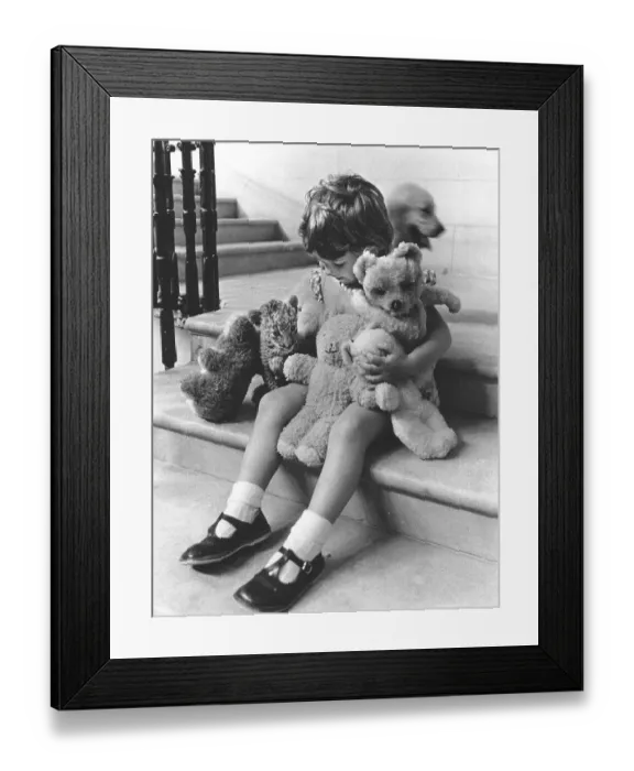 Framed Print : Girl plays with a baby predator and stuffed animals