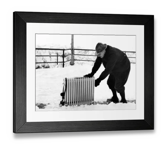 Framed Print : Old man pushes radiator through snow