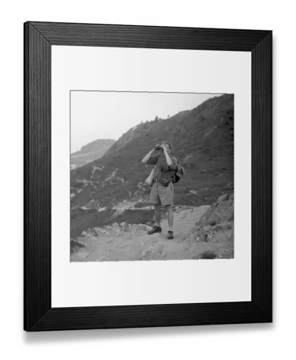 Framed Print : Man standing on a mountain path looking through binoculars Framed Print : Man standing on a mountain path looking through binoculars