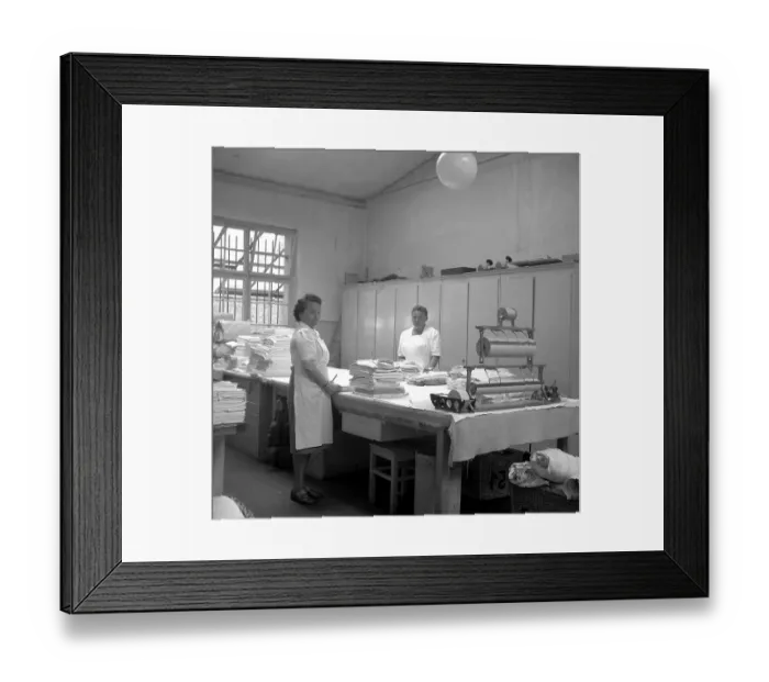 Framed Print : Women folding fabrics around 1950