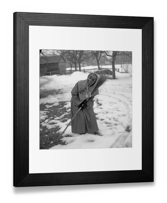 Framed Print : Witch with broom in hand stands in a curvilinear position in the snow Framed Print : Witch with broom in hand stands in a curvilinear position in the snow