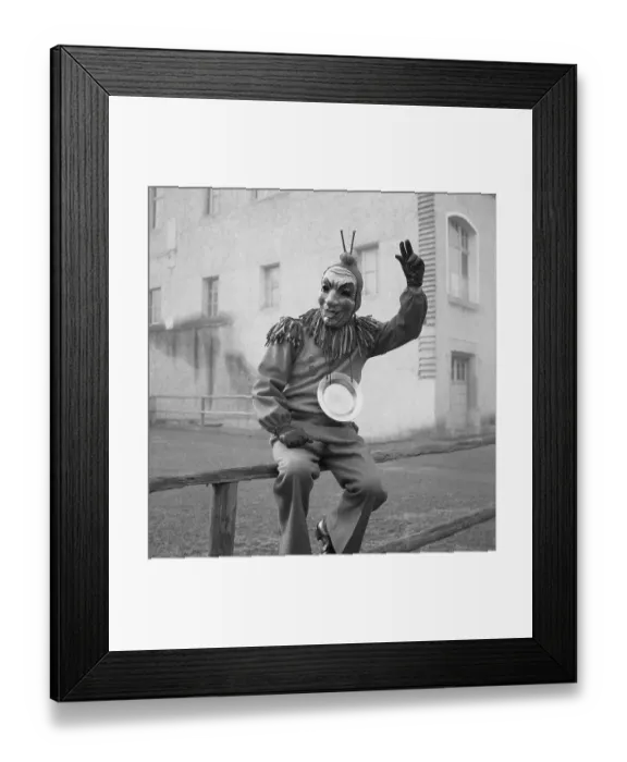 Framed Print : Disguised man sitting on a wooden banister and greeting