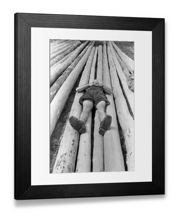Framed Print : Child lying on felled tree trunks and resting Framed Print : Child lying on felled tree trunks and resting