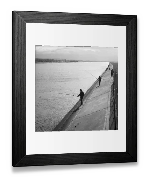 Framed Print : Men standing on the banks of a river and fishing
