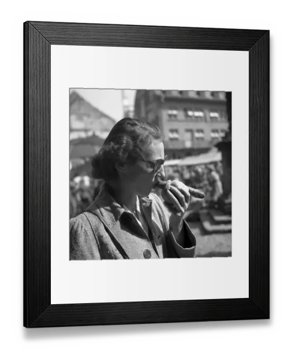 Framed Print : Frau eats bratwurst in bread roll on the market square Framed Print : Frau eats bratwurst in bread roll on the market square