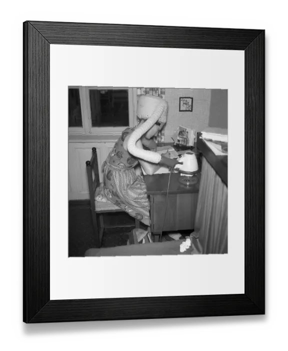Framed Print : A woman dries her hair at the desk
