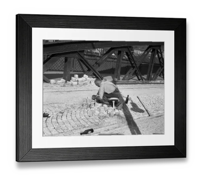 Framed Print : Road worker paving a road with natural stones