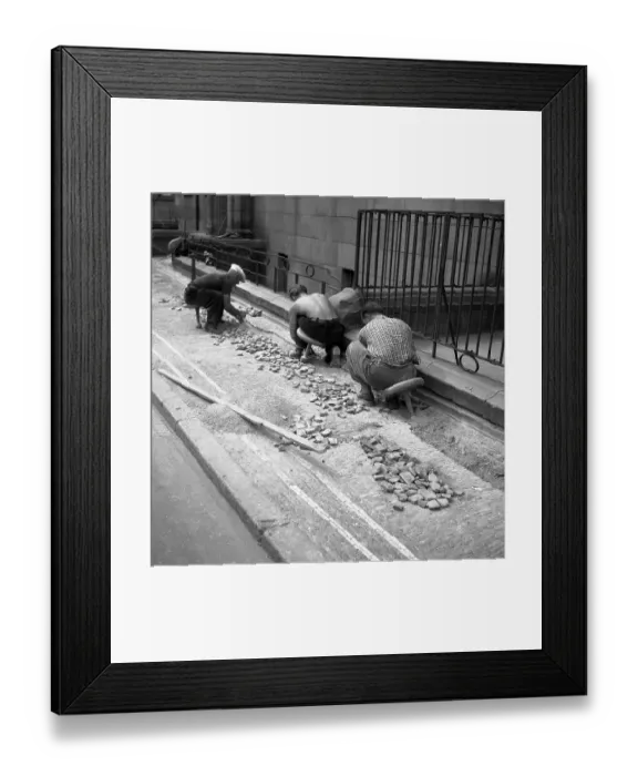 Framed Print : Road workers paving a road with natural stones Framed Print : Road workers paving a road with natural stones