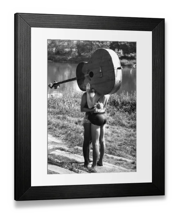 Framed Print : Pair behind big guitar ca. 1970s