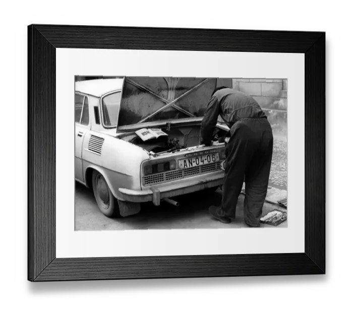 Framed Print : Man repairing car after instruction ca Framed Print : Man repairing car after instruction ca