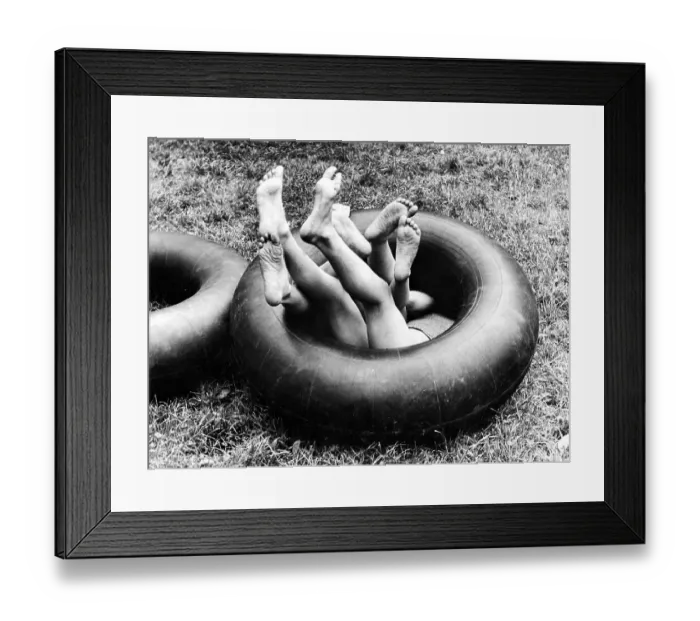 Framed Print : Three children playing in one innertube ca