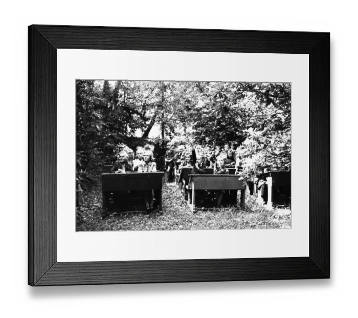 Framed Print : School class sits on wooden benches in the open air Framed Print : School class sits on wooden benches in the open air