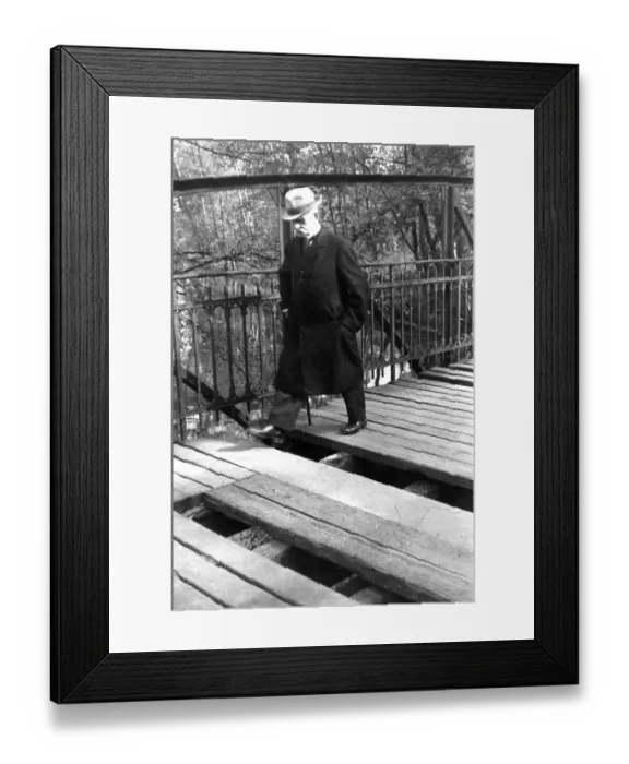 Framed Print : A man with walking stick and hat crosses a broken bridge