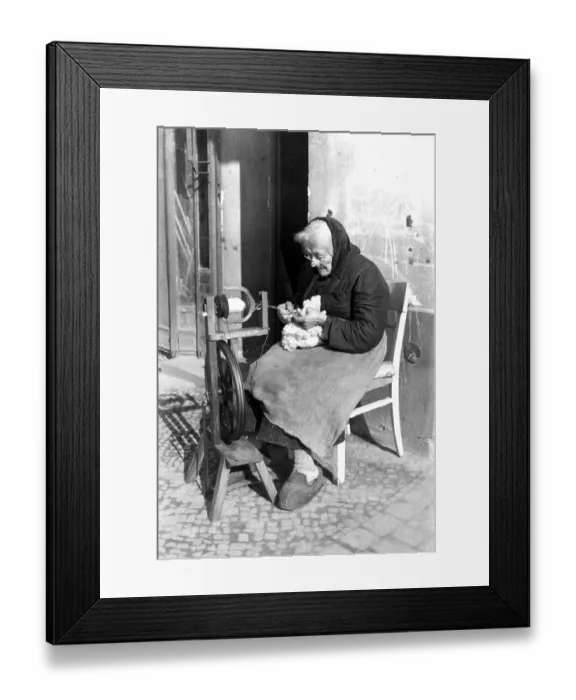 Framed Print : An old woman weaves on the street, ca