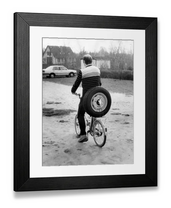 Framed Print : Cyclist transports car tire, approx